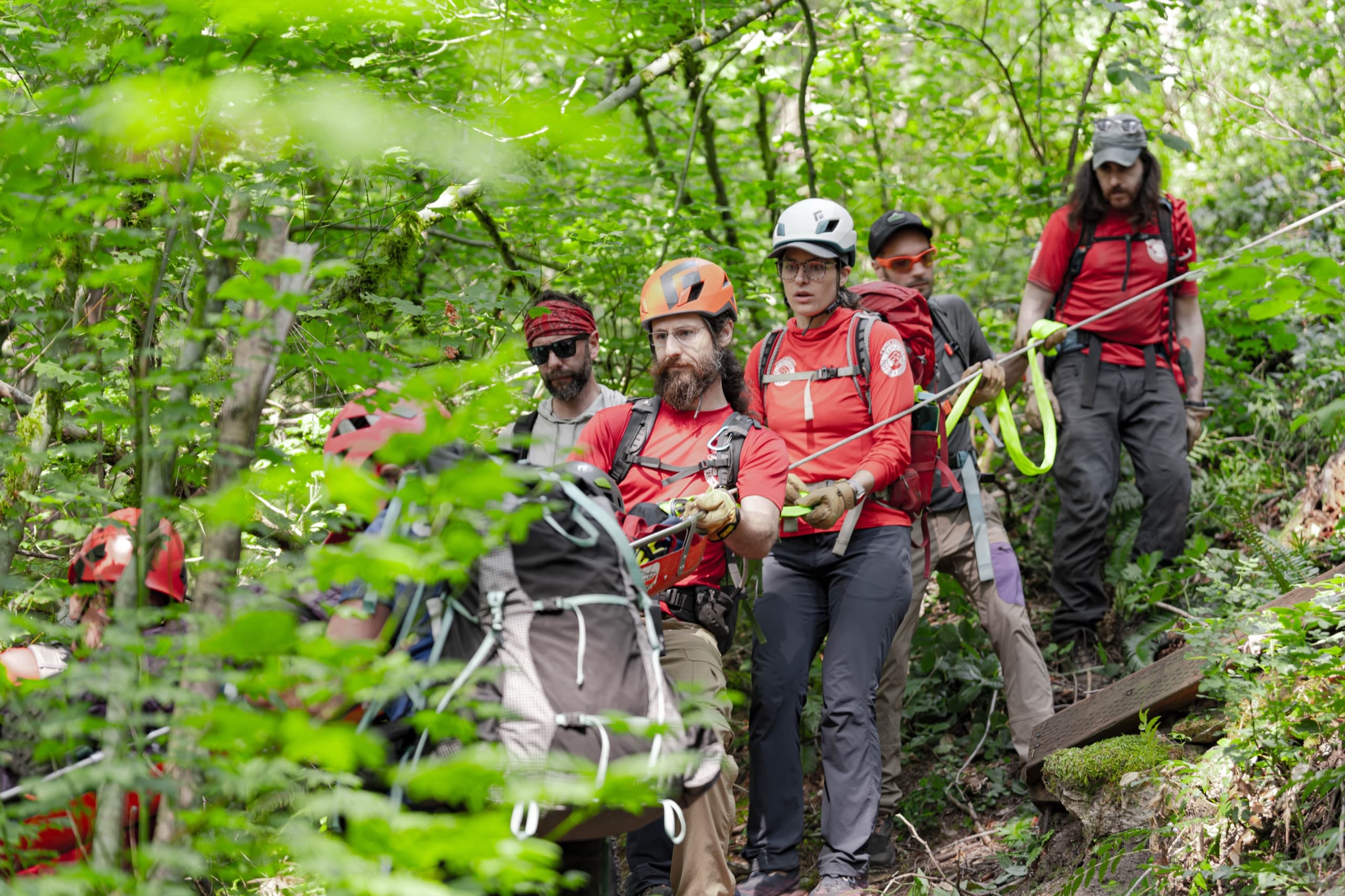 Rescuers working together to manage a rope line on a steep slope